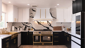 Modern kitchen with black and white design, gold accents, and a large oven.