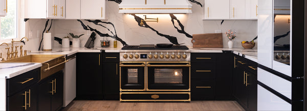 Modern kitchen with black and white design, gold accents, and a large oven.